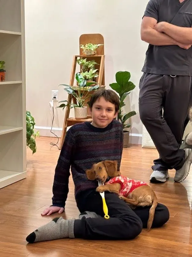 A young patient sitting with a dog